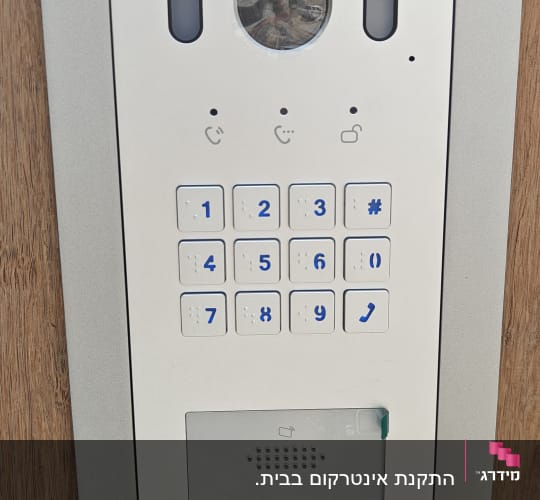 פאנל אינטרקום עם מקשים ומצלמה מותקן על עץ